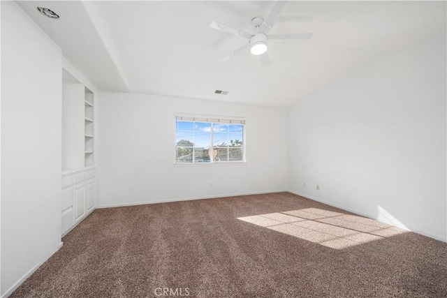 carpeted spare room with ceiling fan and built in features