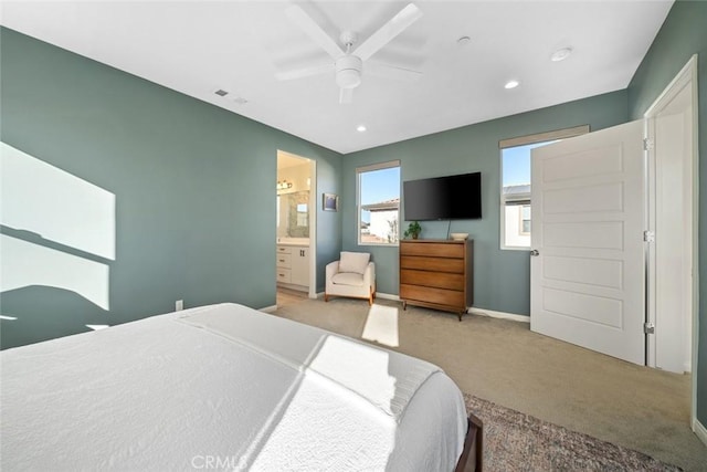 bedroom featuring ceiling fan, ensuite bathroom, and carpet floors