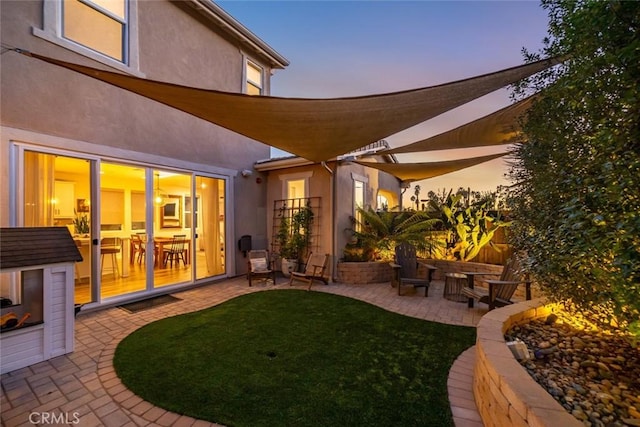 yard at dusk featuring a patio