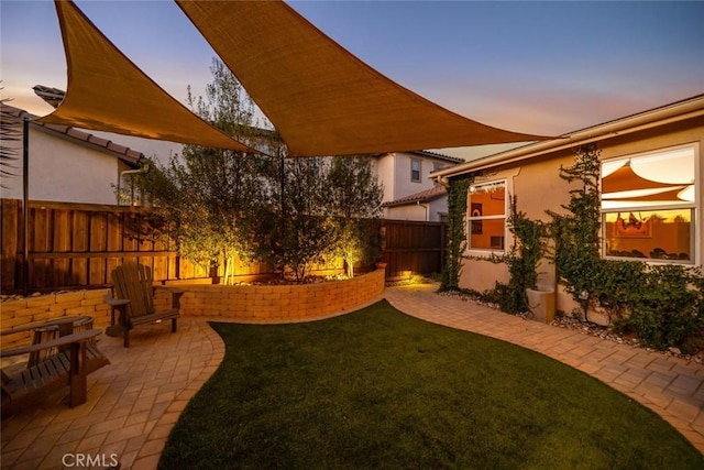 yard at dusk featuring a patio area