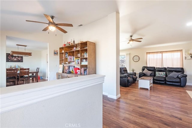 living room featuring ceiling fan and dark wood-type flooring