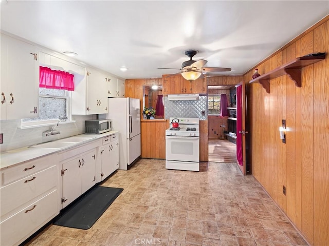 kitchen featuring decorative backsplash, white appliances, ceiling fan, sink, and white cabinets