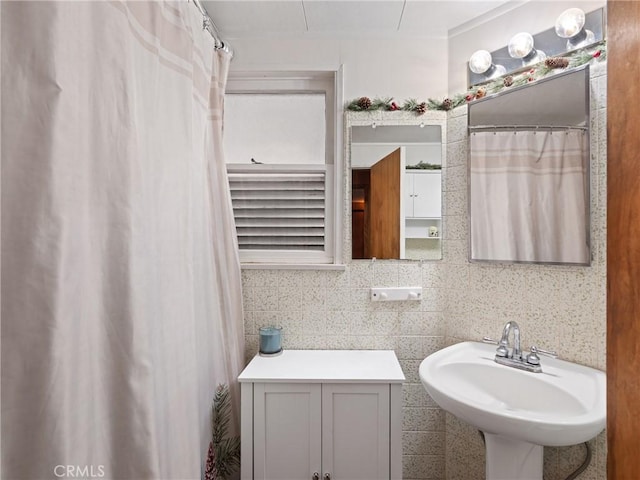 bathroom with backsplash, sink, and tile walls