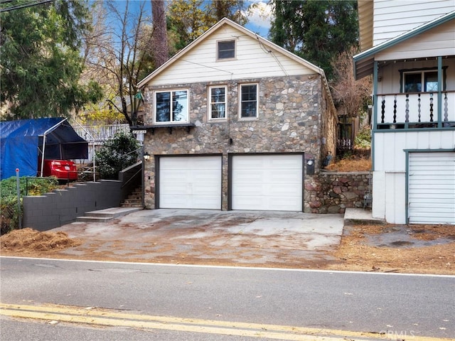 front facade with a balcony, a garage, and a carport