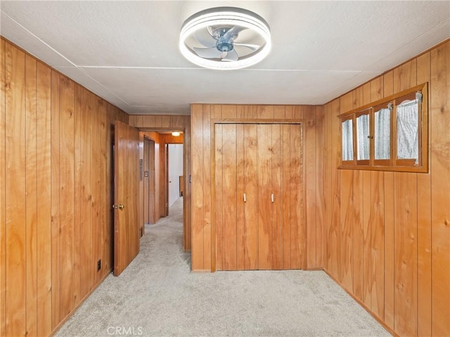 interior space with ceiling fan and wood walls