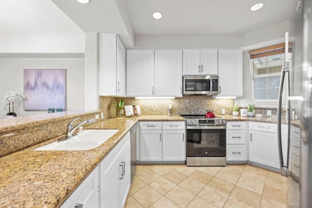 kitchen with backsplash, white cabinetry, sink, and stainless steel appliances