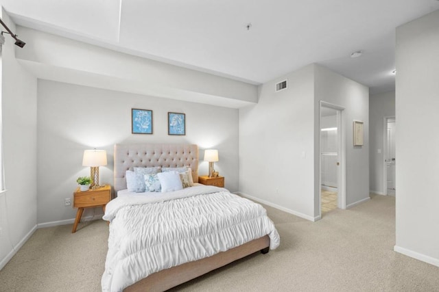 bedroom featuring light carpet and connected bathroom