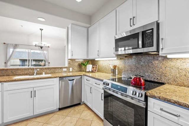 kitchen with white cabinetry, sink, light tile patterned floors, and stainless steel appliances