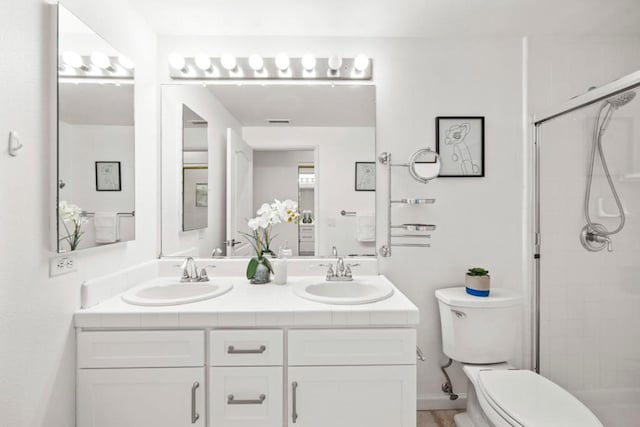 bathroom with vanity, an enclosed shower, and toilet