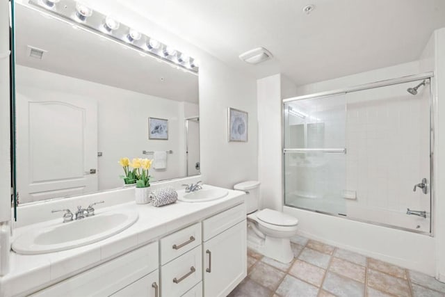 full bathroom featuring combined bath / shower with glass door, vanity, and toilet