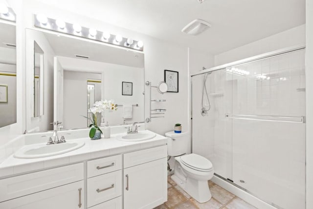 bathroom featuring tile patterned floors, vanity, toilet, and a shower with door