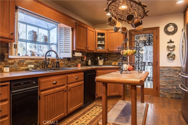 kitchen featuring tasteful backsplash, dishwasher, sink, stainless steel fridge, and light wood-type flooring