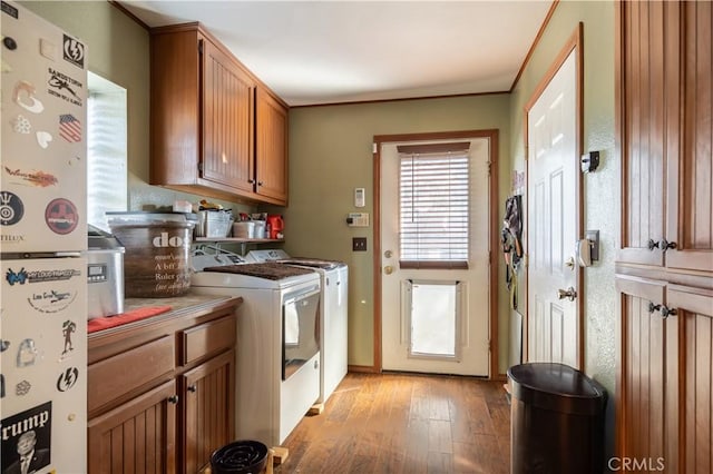 interior space with washer and dryer, ornamental molding, cabinets, and light wood-type flooring