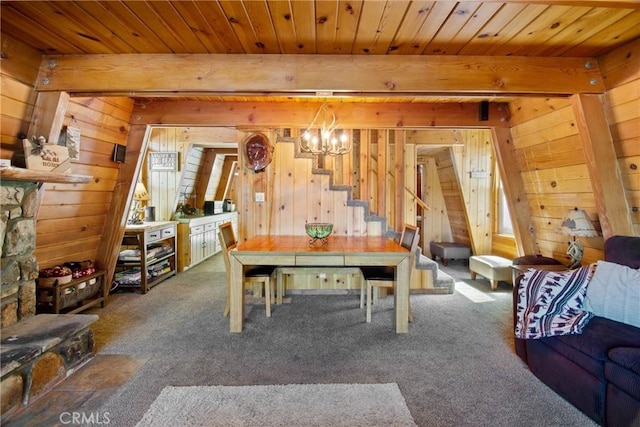 carpeted dining room with beamed ceiling, an inviting chandelier, wooden ceiling, and wood walls