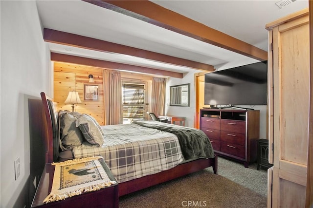 bedroom featuring dark colored carpet and beam ceiling