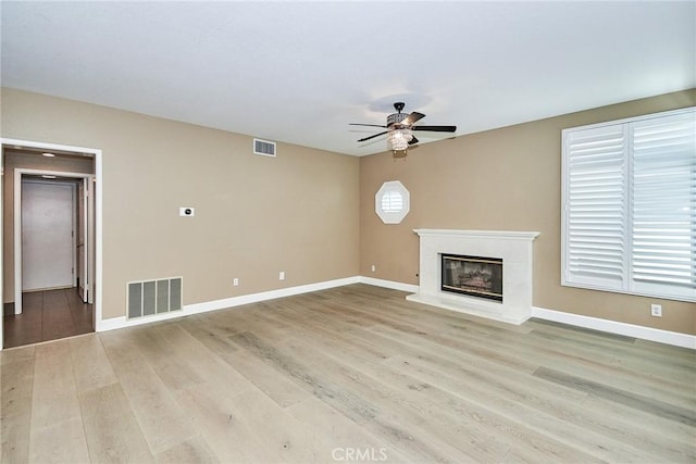 unfurnished living room featuring ceiling fan and light hardwood / wood-style floors