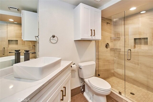 bathroom with toilet, a shower with door, vanity, and tile patterned flooring