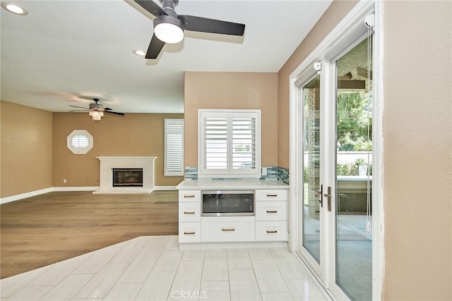 unfurnished living room featuring ceiling fan, light hardwood / wood-style flooring, and french doors