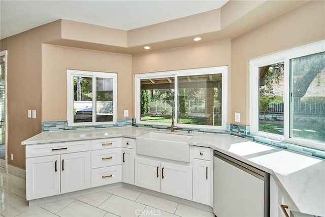 kitchen featuring stainless steel dishwasher, white cabinets, sink, and a healthy amount of sunlight