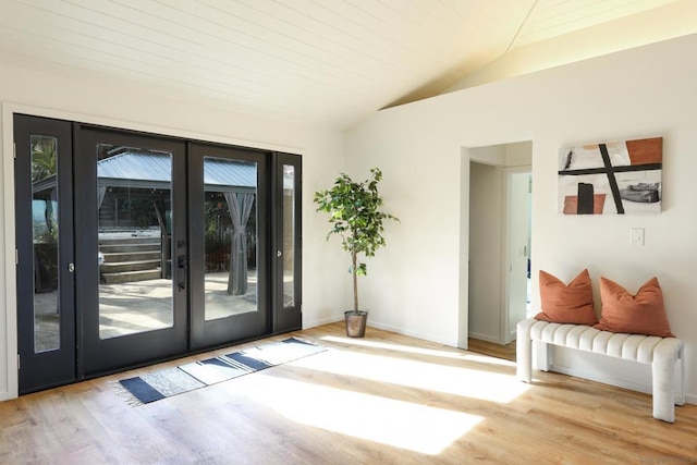 doorway to outside featuring french doors, vaulted ceiling, and light hardwood / wood-style flooring