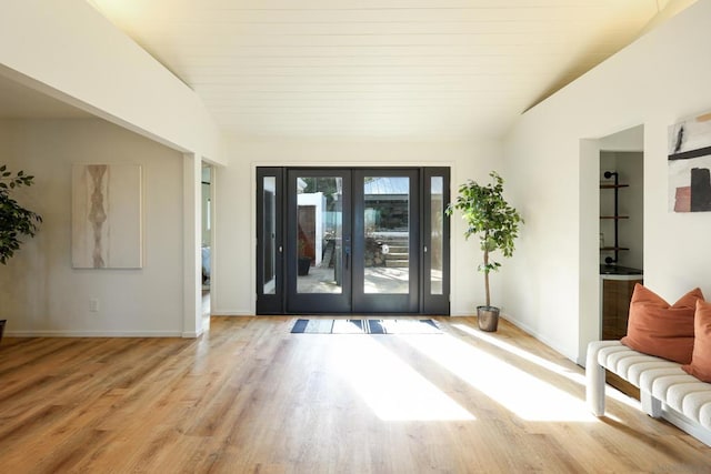 foyer entrance featuring french doors, light hardwood / wood-style floors, and lofted ceiling