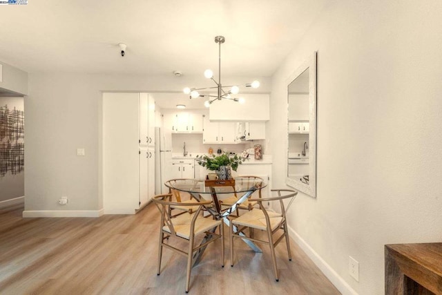 dining area featuring light hardwood / wood-style floors and an inviting chandelier