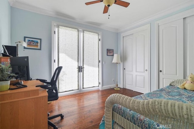 bedroom with ornamental molding, dark wood-type flooring, two closets, and ceiling fan