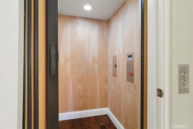 interior details with hardwood / wood-style flooring and elevator