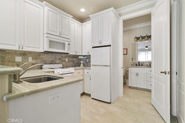 kitchen featuring sink, white cabinets, and white appliances