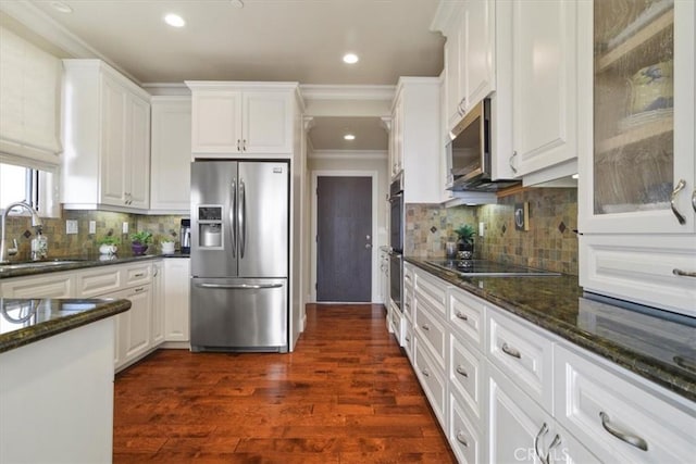 kitchen featuring sink, dark wood-type flooring, dark stone countertops, stainless steel appliances, and white cabinets