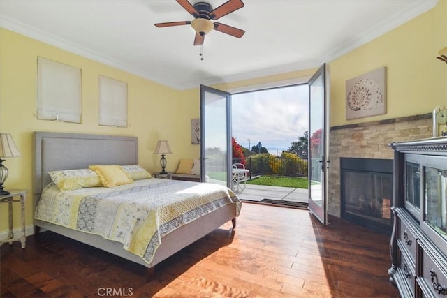 bedroom featuring ceiling fan, dark hardwood / wood-style floors, a fireplace, ornamental molding, and access to outside