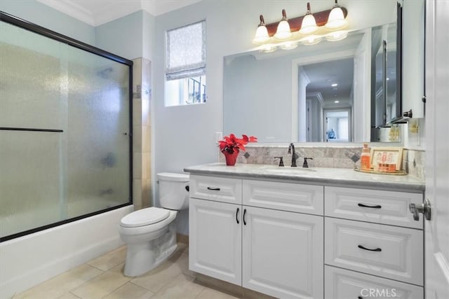 full bathroom with tile patterned floors, toilet, vanity, ornamental molding, and enclosed tub / shower combo