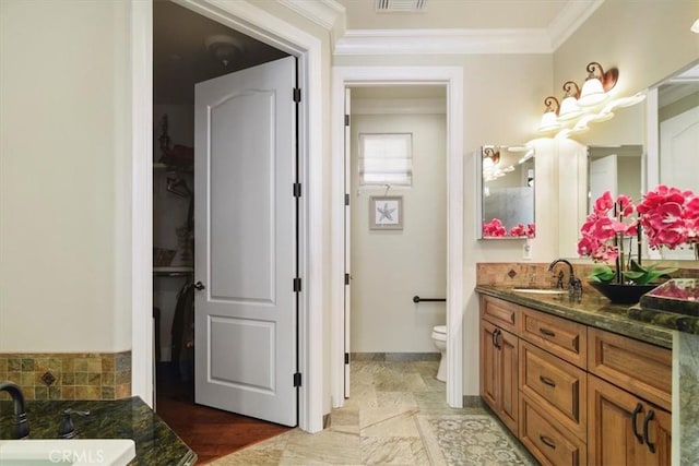 bathroom with vanity, a bathing tub, crown molding, and toilet