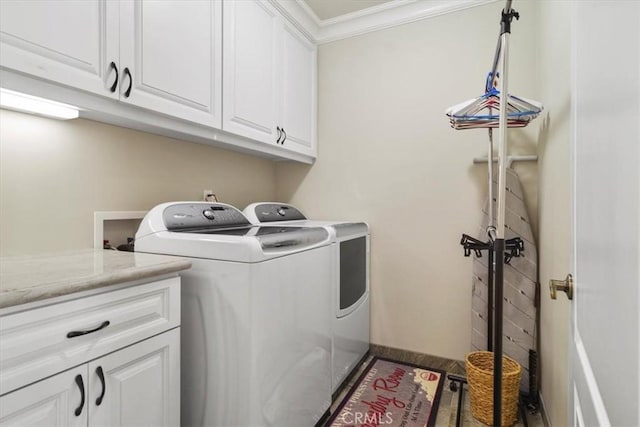 washroom featuring ornamental molding, washing machine and dryer, cabinets, and wood-type flooring