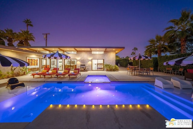 pool at dusk featuring a patio