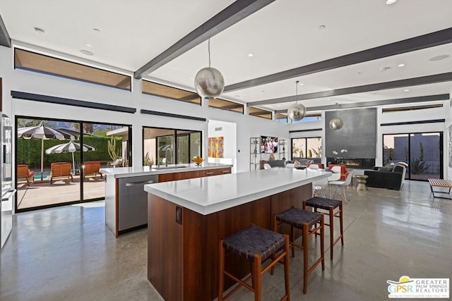 kitchen featuring dishwasher, a kitchen island, concrete floors, and decorative light fixtures