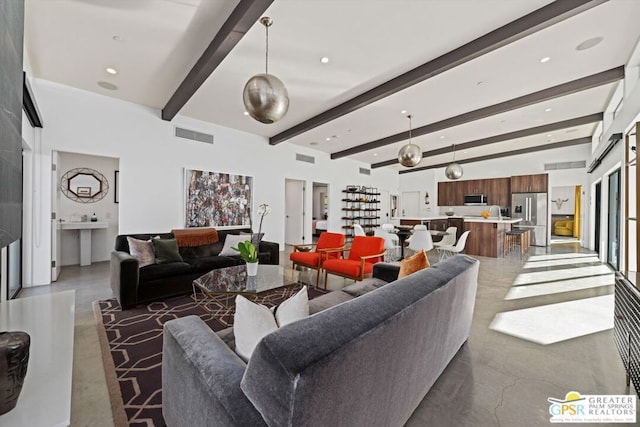 living room with beamed ceiling and concrete floors