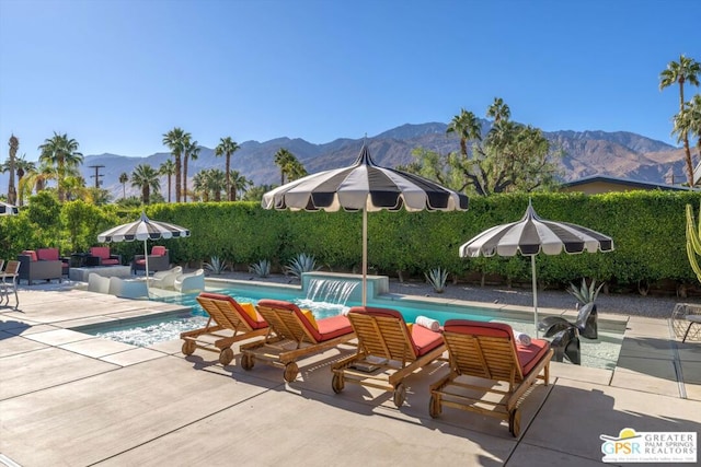 view of pool with a mountain view, a patio, and pool water feature