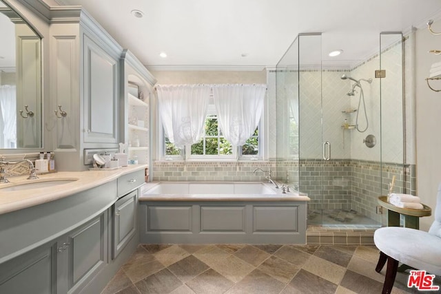 bathroom featuring plus walk in shower, vanity, and crown molding