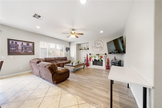 living room featuring ceiling fan and light hardwood / wood-style flooring