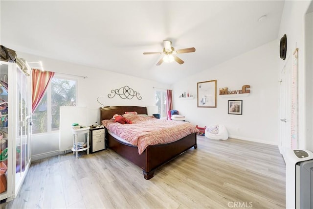 bedroom featuring ceiling fan, light hardwood / wood-style floors, and lofted ceiling