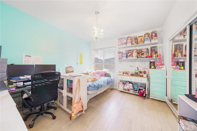 bedroom with light hardwood / wood-style floors and a chandelier