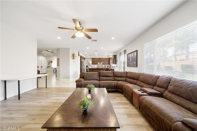 living room with light hardwood / wood-style flooring and ceiling fan