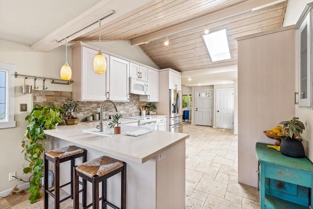 kitchen featuring kitchen peninsula, white cabinets, stainless steel refrigerator with ice dispenser, and a kitchen bar