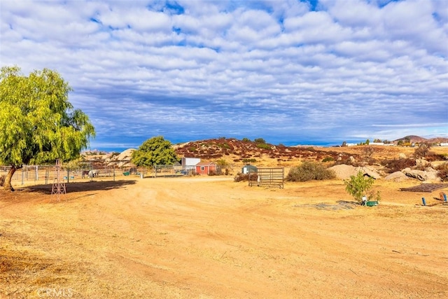 exterior space with fence and a rural view