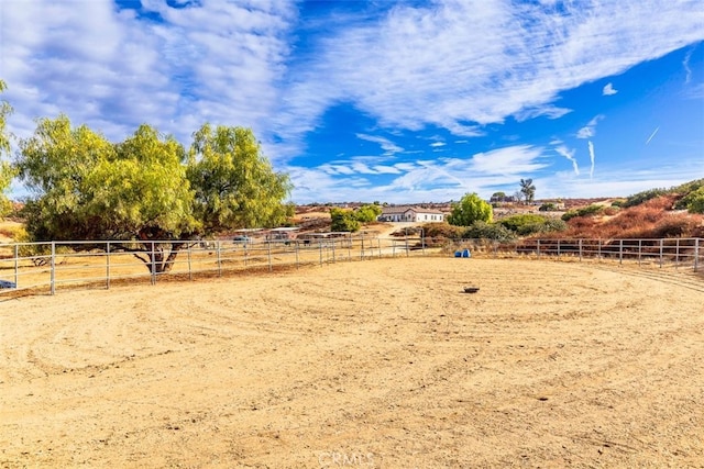 view of yard featuring a rural view, an enclosed area, and fence