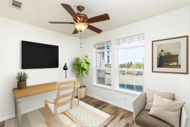 office with baseboards, visible vents, ceiling fan, and wood finished floors