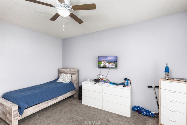 bedroom with ceiling fan and dark colored carpet