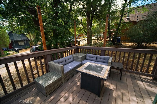 deck featuring an outdoor living space with a fire pit