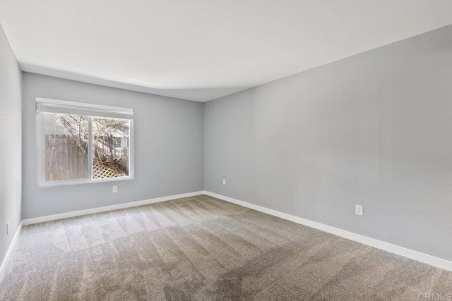 carpeted spare room with baseboards